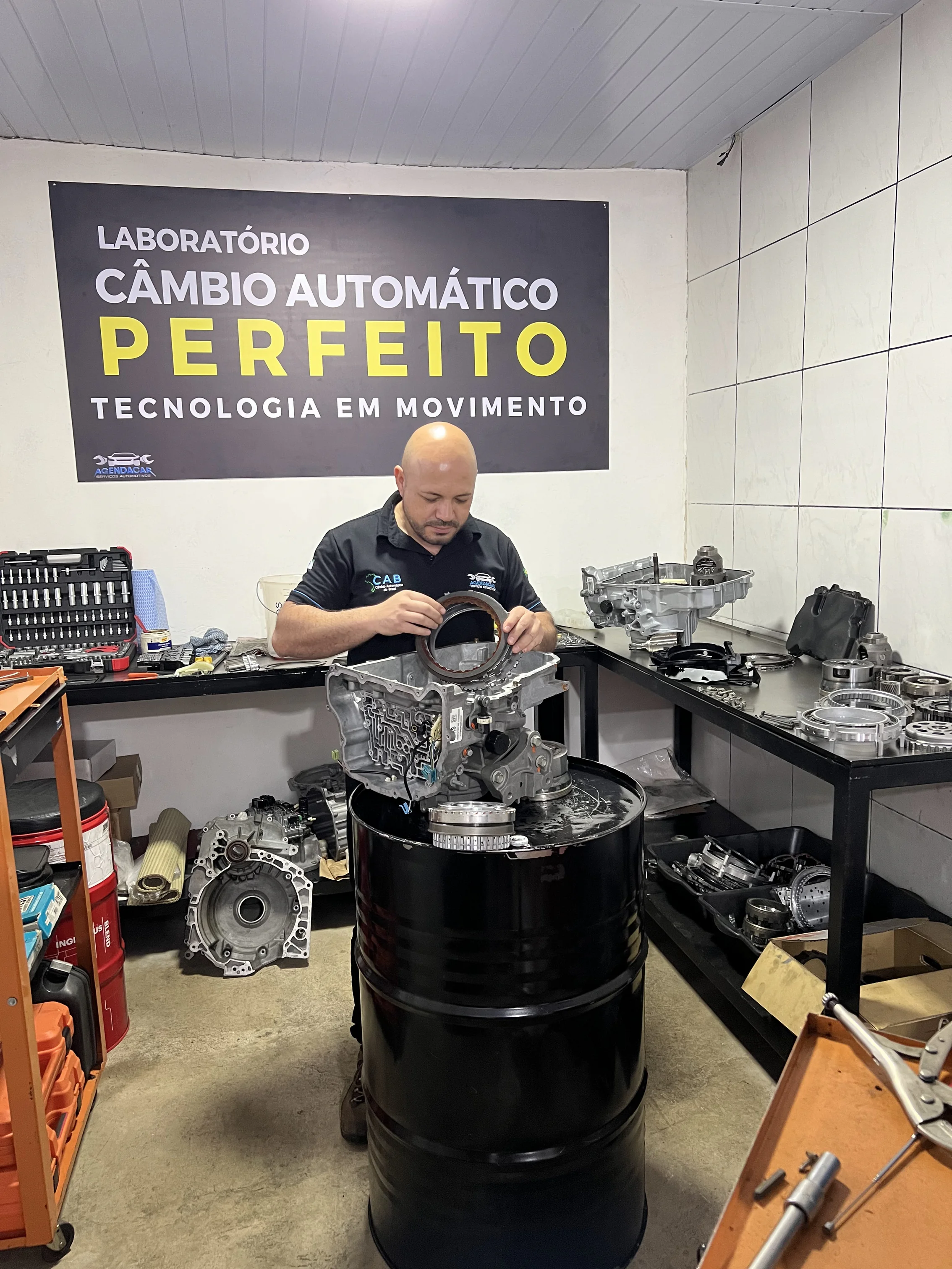 Técnico remontando câmbio automático sobre bancada especializada